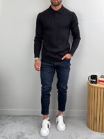 Muški polo džemper u crnoj boji u kombinaciju sa tamno plavim farmerkama i belim patikama, prednji prikaz.