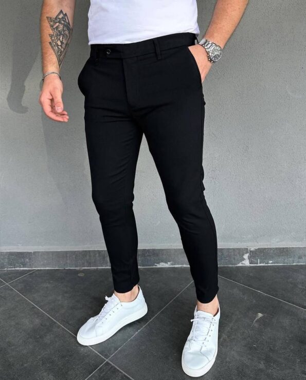 Crne elegantne muske pantalone slim kroja na modelu uz belu majicu i bele patike
