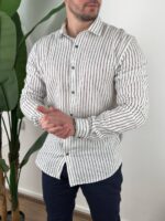 Bela prugasta muška lanena košulja sa tamnim pantalonama u poslovnoj kombinaciji