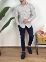 Bela prugasta muška lanena košulja sa zaobljenim porubom preko pantalona