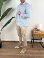 Tamno prugasta muška lanena košulja sa krem chino pantalonama u frontalnom kadru