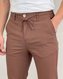 Detalj struka braon muških pantalona sa lastišem i vezanim pertlama u čvor