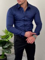 Teget elegantna muška pamučna košulja celom dužinom uz bež pantalone, frontalno