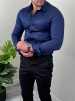 Teget elegantna muška pamučna košulja u dinamičnoj pozi sa rukom kraj struka