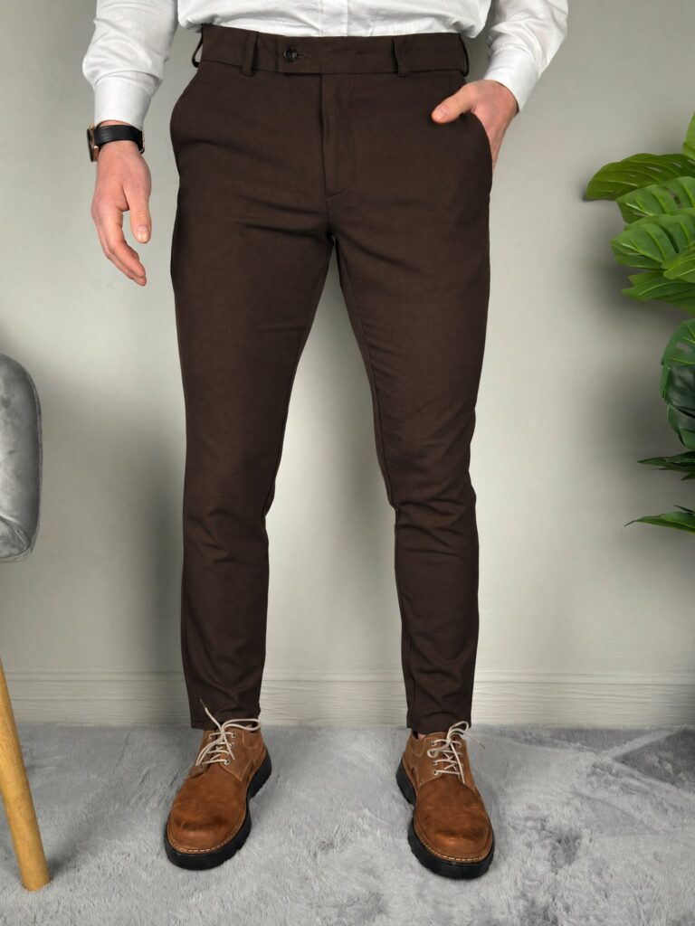 Elegantne braon pantalone na modelu, prednji ugao, slim kroj uz belu košulju i smeđe kožne cipele