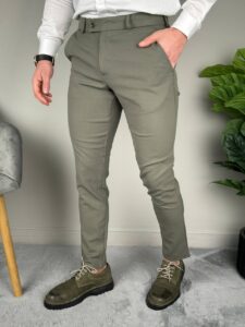 Maslinaste elegantne muške pantalone, ruka u bočnom džepu i sat na zglobu, frontalan kadar