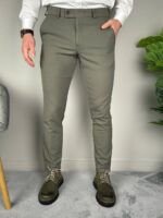 Elegantne muške pantalone maslinaste u punoj dužini, obe ruke u prednjim džepovima