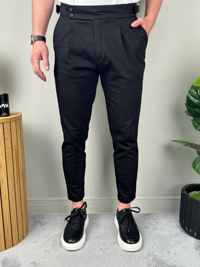 Bočni profil crnih elegantnih muških pantalona sa podesivim pojasom, model uz stepenice
