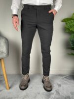 Elegantne tamnosive muške pantalone uz dužinu do gležnja iznad smeđih derbi cipela na sivom podu