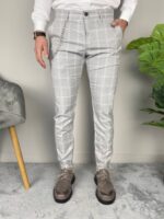 Karirane muške pantalone sive na modelu, ruka u džepu sa srebrnim lančićem, frontalni snimak