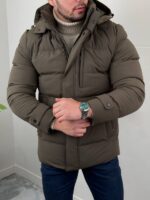 Maslinasta muška zimska jakna, model rukom popravlja sat, detalj rukava