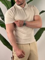 Bež polo majica sa zipom, model gleda u stranu, ruka pored tela