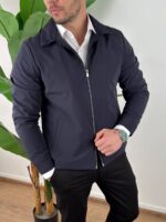 Teget muška prelazna jakna two-way zip zatvorena na modelu sa crnim pantalonama
