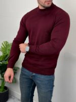 Bordo rolka u poluprofilu prikazuje meku teksturu pletiva preko ramena i grudi modela