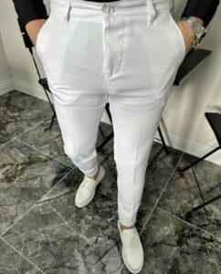 Muške bele pantalone klasičnog kroja na modelu uz tamni sako i bele patike, frontalni kadar