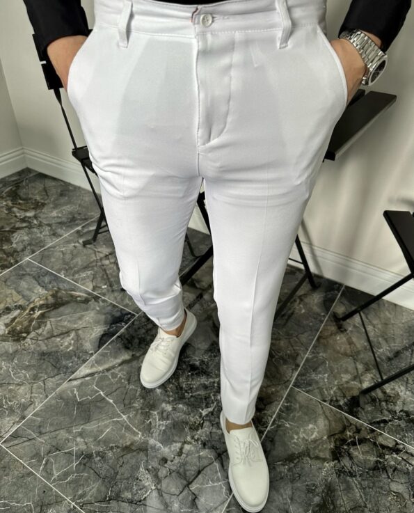Muške bele pantalone klasičnog kroja na modelu uz tamni sako i bele patike, frontalni kadar
