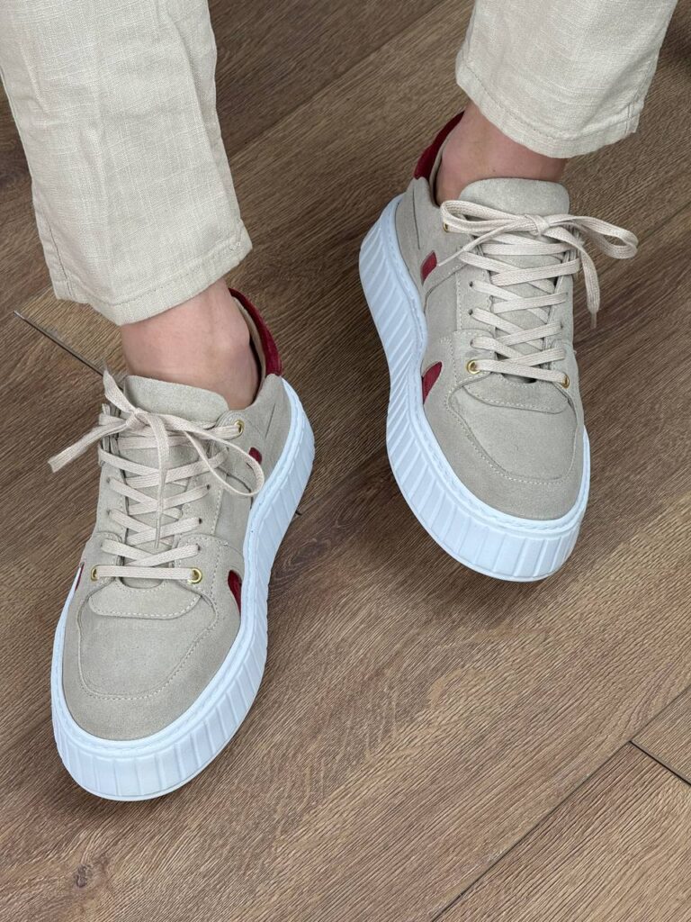Bež muške kožne patike na modelu u krem pantalonama, bočni snimak sa belim đonom