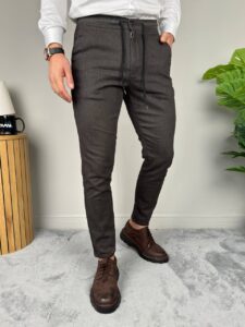 Muške pantalone sa učkurom u antracit boji, model leva ruka u džepu, bela košulja i braon cipele