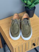 Detalj maslinastih muških Sebago cipela sa belim đonom, struktura prevrnute kože