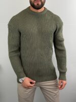 Maslinasto zeleni muški džemper loose fit, model sa rukom uz bradu i satom na zglobu