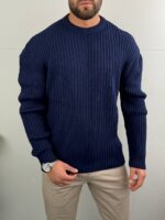 Teget plavi muški džemper loose fit u kombinaciji sa bež pantalonama, frontalni celovit prikaz