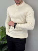 Bež muški polo džemper pamučni u poluprofilu sa rukom u džepu pantalona