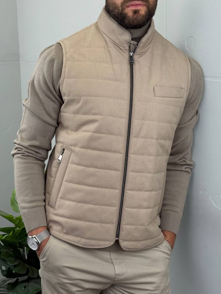 Krupni plan bočnog rajsferšlus džepa i šavova bež muškog prošivenog prsluka