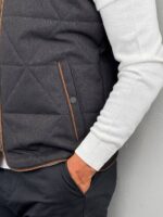 Detalj rajsferšlusa i ruske kragne na crnom muškom quilted prsluku