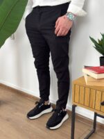 Crne pamučne letnje pantalone, profilni kadar uz drvenu klupu i biljku u pozadini