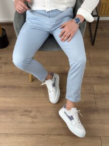 Svetloplave pamučne letnje pantalone na modelu uz belu košulju i bele patike, kadar do kolena
