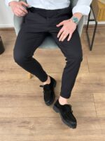 Polubočni profil krem elegantnih pantalona sa podesivim pojasom uz drvenu stolicu