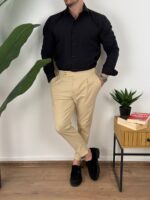 Bočni snimak krem elegantnih muških pantalona sa podesivim pojasom, lagana poza modela