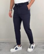 Teget muške pantalone sa lastišem na modelu u belom duksu i belim patikama