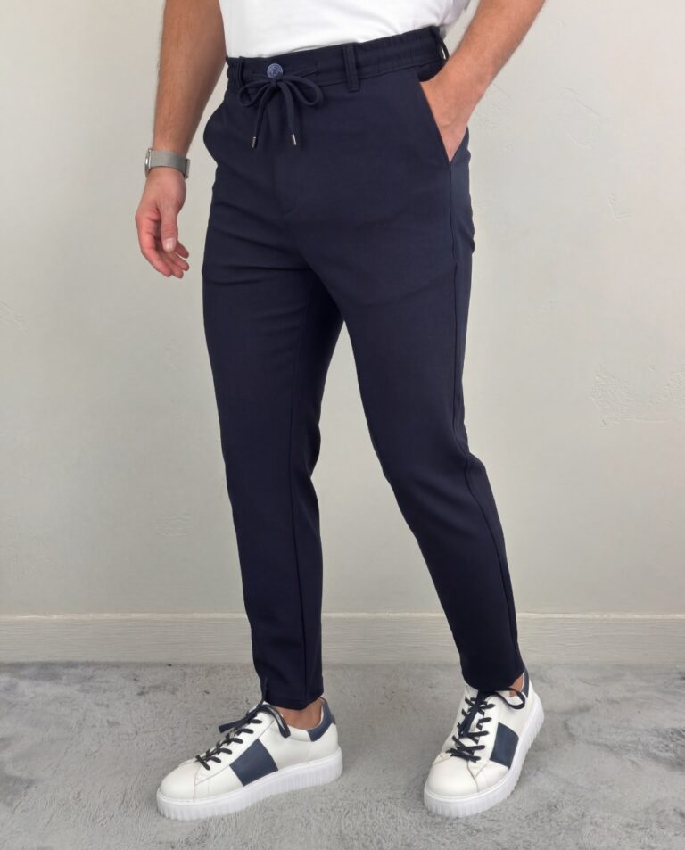 Teget muške pantalone sa lastišem na modelu u belom duksu i belim patikama