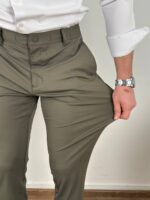Maslinaste ultra flex pantalone iz bočnog ugla uz tamne patike i belu košulju