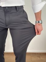 Bočni ugao tamno sivih ultra flex pantalona sa vidljivim padom nogavice